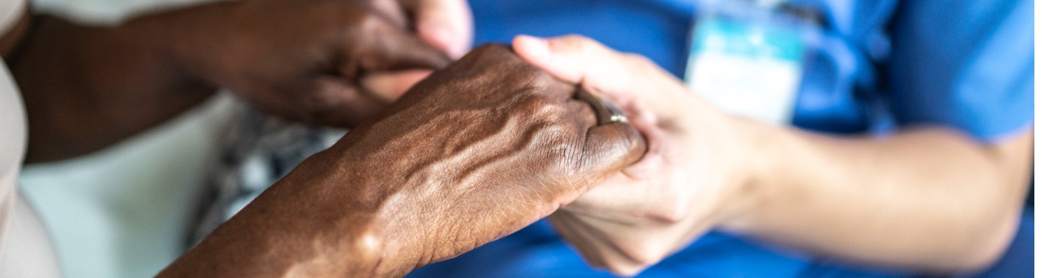 Cropped close up of a two people holding hands in a caring and supportive manner